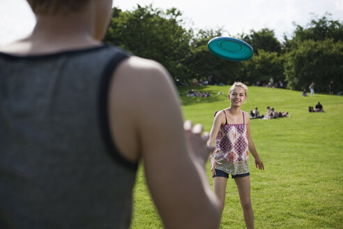 Deutschland, Berlin, Jugendliches Mädchen und Junge spielen Frisbee im Park - WESTF015298