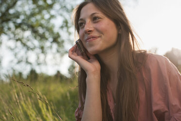 Deutschland, Berlin, Teenager-Mädchen mit Mobiltelefon, lächelnd - WESTF015317