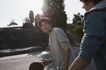 Deutschland, Berlin, Teenager spielen Basketball auf einem Spielplatz - WESTF015318