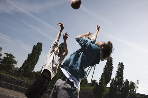 Deutschland, Berlin, Teenager-Jungen Basketball auf dem Spielplatz - WESTF015355