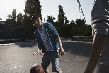 Deutschland, Berlin, Teenager spielen Basketball auf einem Spielplatz - WESTF015372