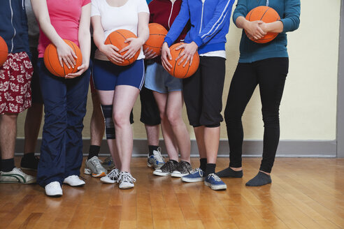 Deutschland, Berlin, Menschen stehen und halten Basketball - BAEF000158