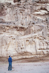 Jordan, Wadi Rum, Man looking at rock wall - NHF001233