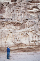 Jordanien, Wadi Rum, Mann schaut auf Felswand - NHF001233