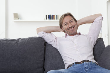 Man relaxing on sofa, smiling - LDF000897