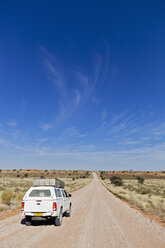 Afrika, Namibia, Kalahari, Landfahrzeug auf einer Schotterpiste - FOF002316