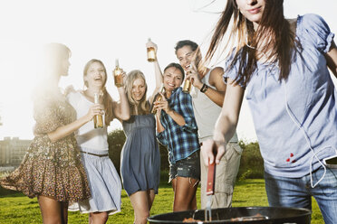 Deutschland, Köln, Frau beim Grillen mit Freunden im Hintergrund - JOF000112