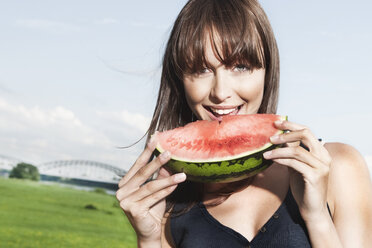 Germany, Cologne, Young woman eating watermelon, portrait - JOF000113