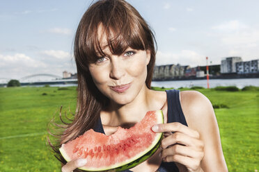 Germany, Cologne, Young woman eating watermelon, portrait - JOF000125