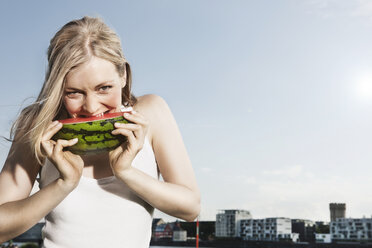 Germany, Cologne, Young woman eating watermelon, portrait - JOF000148