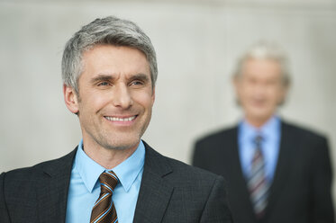 Germany, Hamburg, Businessmen, mature man smiling in foreground - WESTF015409