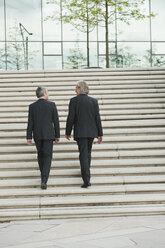 Germany, Hamburg, Businessmen climbing steps together - WESTF015435