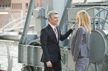 Deutschland, Hamburg, Geschäftsleute diskutieren am Hafen - WESTF015444