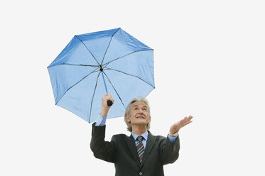 Germany, Hamburg, Businessman holding umbrella, looking up - WESTF015453
