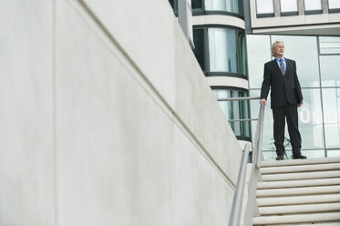 Germany, Hamburg, Businessman standing at steps - WESTF015470