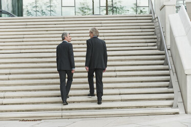 Germany, Hamburg, Businessmen climbing steps together - WESTF015476