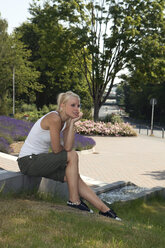 Deutschland, Dortmund, Junge Frau sitzt und schaut weg - SKF000269