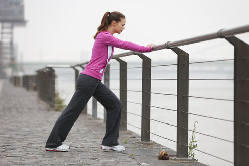 Germany, Cologne, Young woman doing exercise - SKF000299