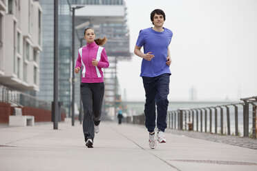 Deutschland, Köln, Junger Mann und Frau beim Joggen - SKF000303