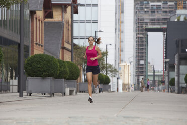 Germany, Cologne, Young woman jogging - SKF000321