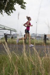 Deutschland, Köln, Junge Frau beim Joggen - SKF000327