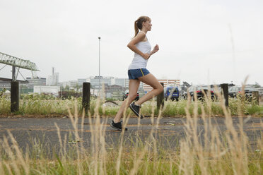 Deutschland, Köln, Junge Frau beim Joggen - SKF000341