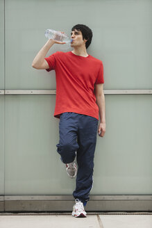 Germany, Cologne, Young man drinking water - SKF000345