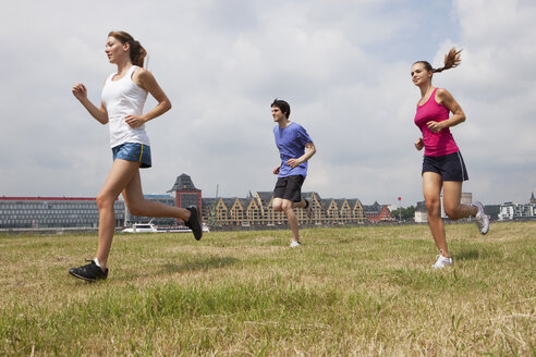 Germany, Cologne, Young man and women jogging - SKF000362