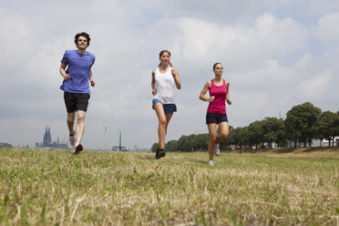 Deutschland, Köln, Junger Mann und Frauen beim Joggen - SKF000365