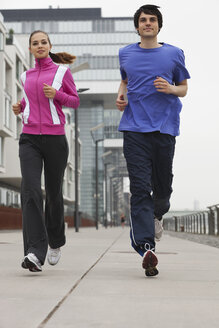 Germany, Cologne, Young man and woman jogging - SKF000369