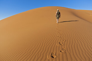 Afrika, Namibia, Namib Naukluft National Park, Mann läuft auf Sand in der Namib Wüste - FOF002477