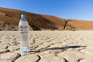 Afrika, Namibia, Namib-Wüste, Wasserflasche auf trockener Lehmpfanne im Namib-Naukluft-Nationalpark - FOF002382