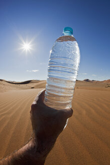 Afrika, Namibia, Namib-Wüste, Namib-Naukluft-Nationalpark, Älterer Mann hält eine Flasche Wasser - FOF002398