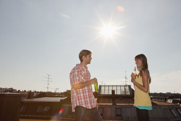 Germany, Bavaria, Munich, Man and woman talking on rooftop - SKF000377