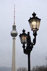 Deutschland, Berlin, Fernsehturm mit Straßenbeleuchtung in der Abenddämmerung - WVF000049