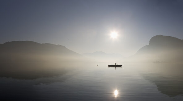 Österreich, Mondsee, Blick auf Fischerboot im See bei nebligem Morgen - WWF001678