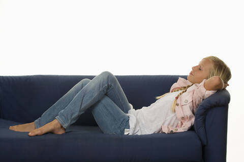 Girl (12-13 Years) resting on couch stock photo