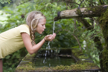 Austria, Mondsee, Girl (12-13 Years) drinking water from water spout - WWF001618