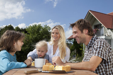 Deutschland, München, Familie beim gemeinsamen Frühstück im Garten - RBF000390