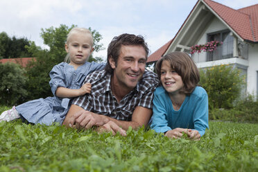 Deutschland, München, Vater mit Kindern im Garten, lächelnd - RBF000396