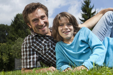 Deutschland, München, Vater und Sohn (10-11 Jahre) im Garten, lächelnd, Portrait - RBF000407