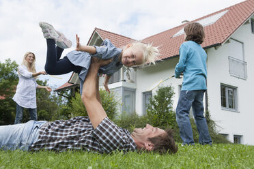 Deutschland, München, Familie hat Spaß im Garten, lächelnd - RBF000325