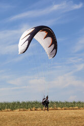 Deutschland, Mosel, Person beim Fallschirmspringen, Landung auf Landschaft - CSF013653
