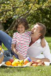 Deutschland, Bayern, Vater und Tochter (8-9 Jahre) haben Spaß beim Picknick, lächelnd - MAEF002573