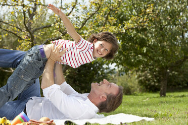 Deutschland, Bayern, Vater und Tochter (8-9 Jahre) haben Spaß beim Picknick, lächelnd - MAEF002577