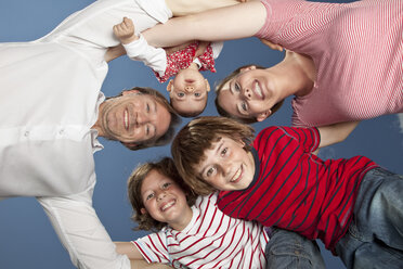 Germany, Bavaria, Family standing in huddle, smiling, portrait - MAEF002594