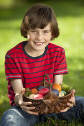 Deutschland, Junge (10-11 Jahre) lächelnd mit Ostereierkorb, Porträt - MAEF002514