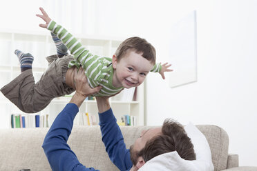 Germany, Bavaria, Munich, Father playing with boy (2-3 Years) on sofa - RBF000328