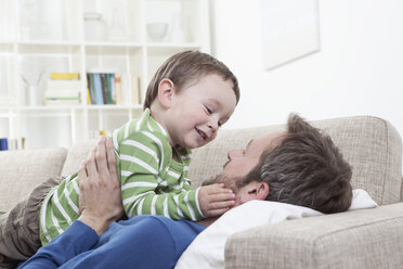 Germany, Bavaria, Munich, Father and son (2-3 Years) on sofa - RBF000331