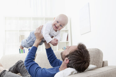 Germany, Bavaria, Munich, Father playing with baby boy (6-11 Months) on sofa - RBF000333